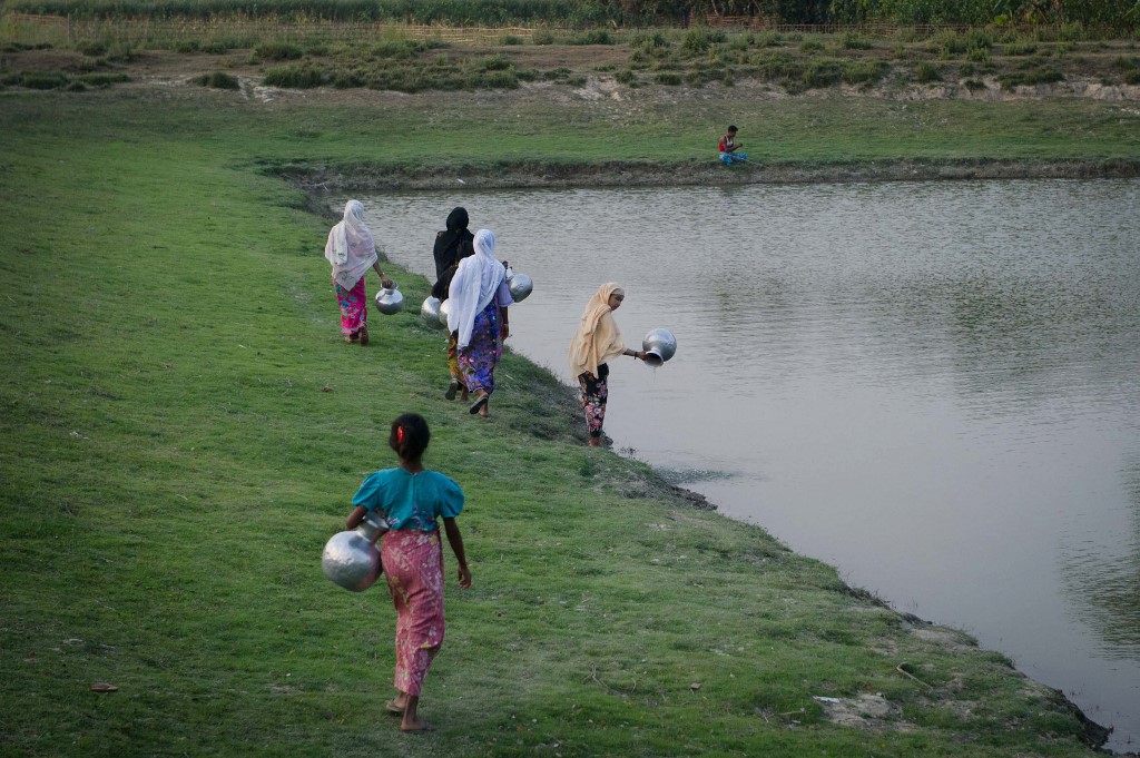 This photograph taken on March 10, 2018, Rohingya women collects water from a pond at Shan Taung village in the outskirt of Mrauk U township located in Rakhine state close to Bangladesh border. (Phyo Hein Kyaw / AFP)