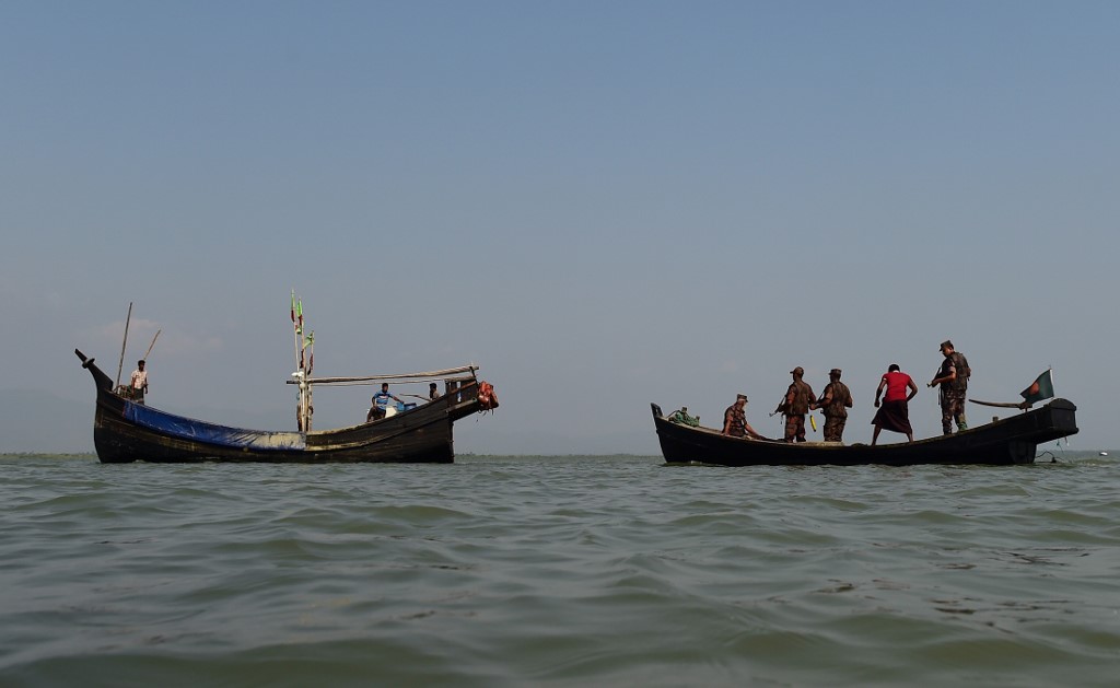 This photograph taken on April 6, 2018 shows Bangladesh Border Guard (BGB) personnel searching a fishing boat during their patrol along the Naf River in Teknaf, along the border between Myanmar and Bangladesh. (Munir Uz Zaman / AFP)