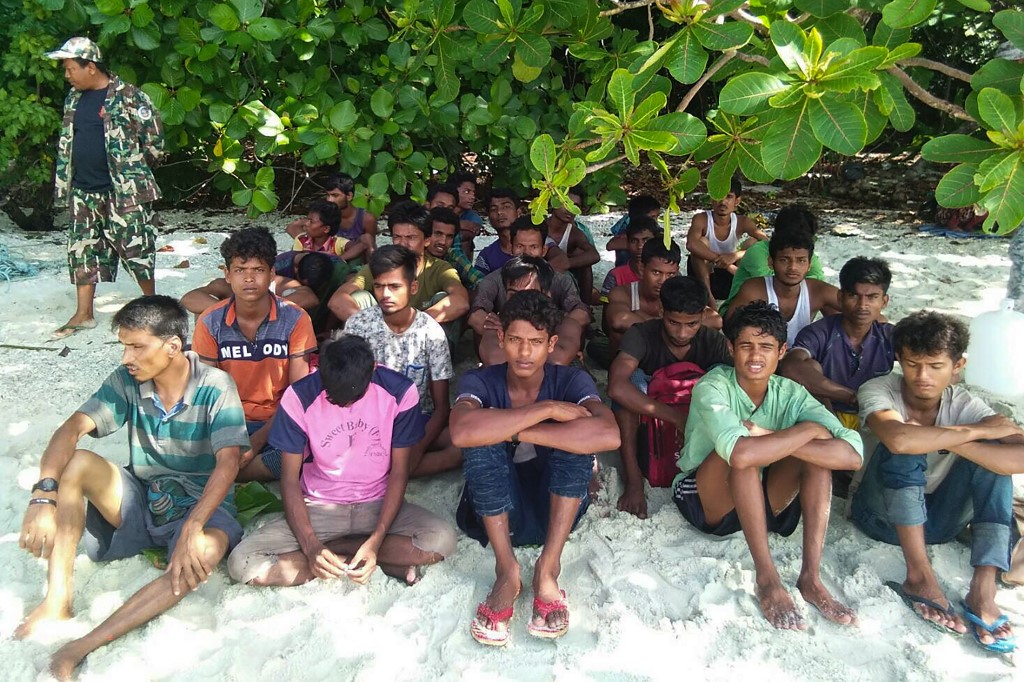  A group of Rohingya Muslims sit on the sand at the Tarutao Marine National Park on Rawi island, southern Thailand. (Handout / Department of National Parks, Wildlife and Plant Conservation / AFP)