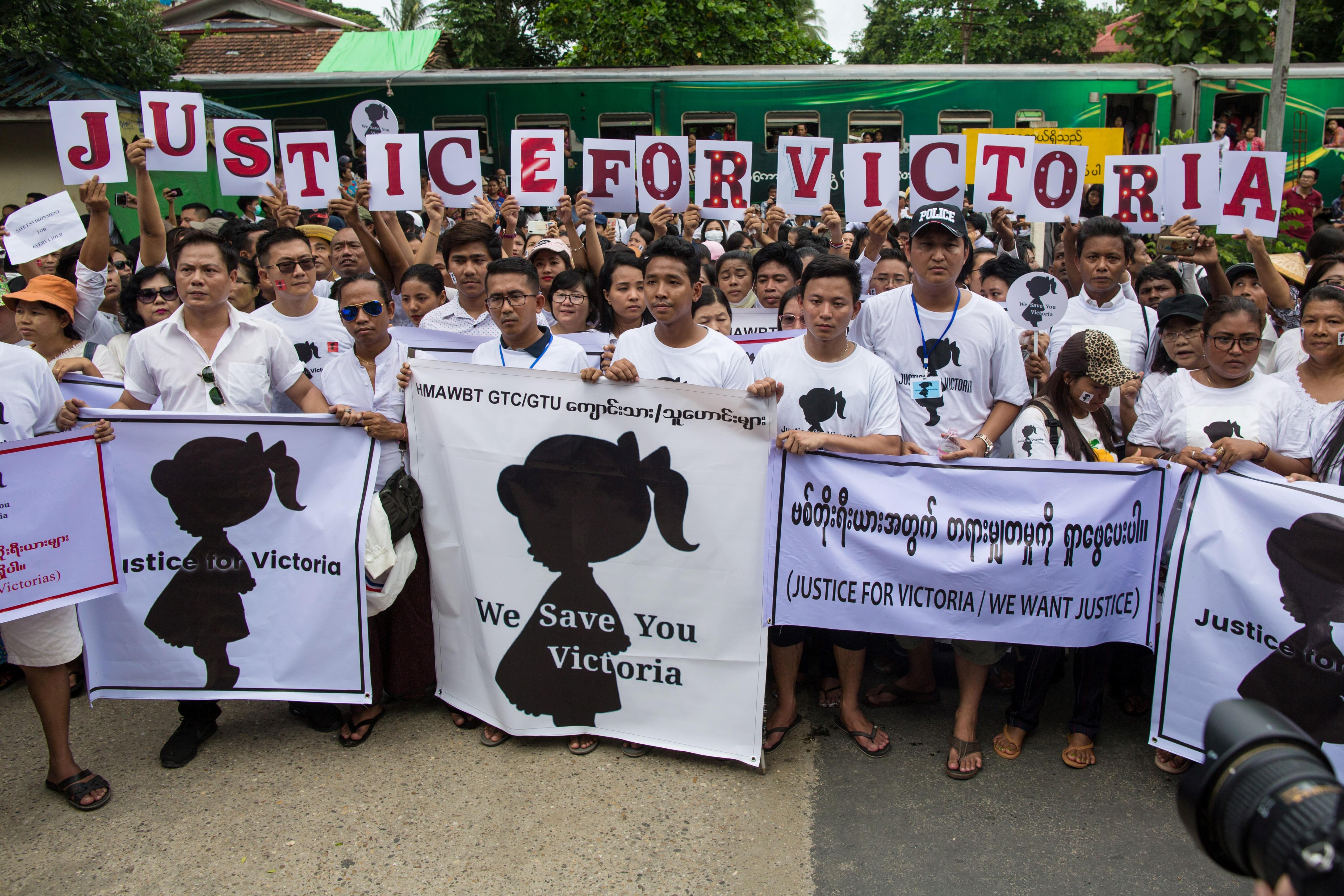 Protesters hold signs during the demonstration demanding justice for a two-year-old who was raped and given the pseudonym "Victoria" in front of the Central Investigation Department (CID) in Yangon on July 6, 2019. (Sai Aung Main / AFP)