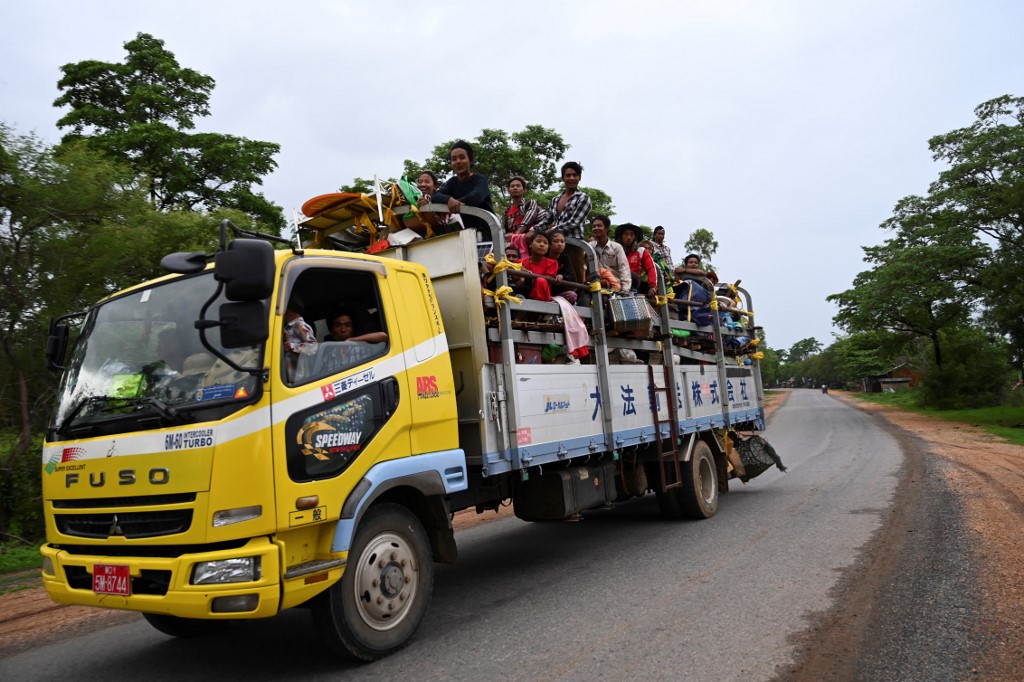 A representational image: People ride on the back of a truck with their belongings along a road in Magway on July 7, 2019. (Ye Aung Thu / AFP)