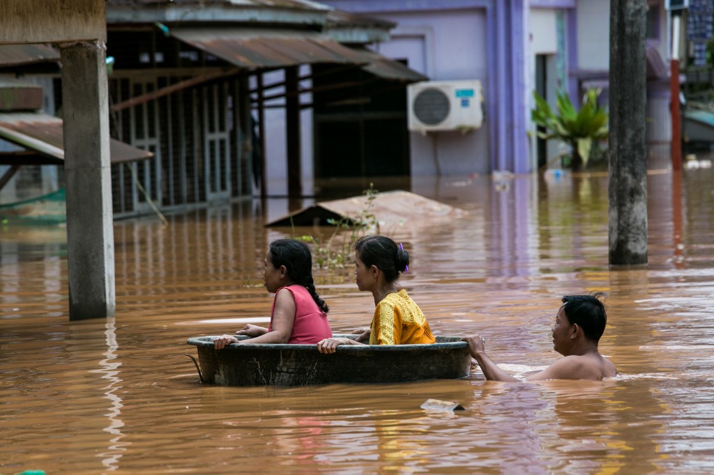  Residents use a plastic tub as floodwaters submerged areas of Ye township in Mon State on August 11, 2019. (Sai Aung Main / AFP)