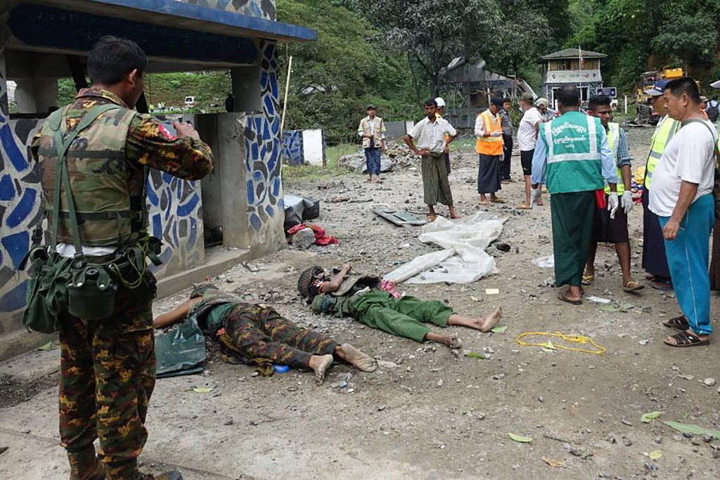 People look at bodies lying on the ground in the compound of the Gote Twin police station in Shan state on August 15, 2019, after it was attacked by ethnic rebel groups. (STR / AFP)