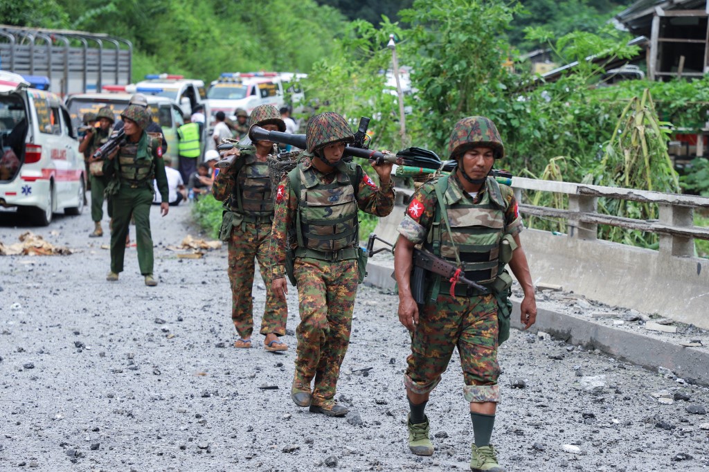 Armed government troops cross a bomb damaged bridge outside the compound of the Gote Twin police station in Shan state on August 15, 2019, after it was attacked by ethnic rebel groups. (STR / AFP)