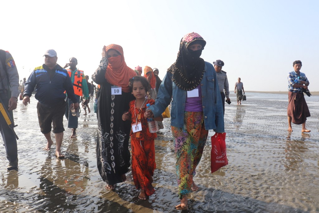  Rohingya people who were arrested at sea in December walk on a beach after being transported by Myanmar authorities to Thalchaung near Sittwe in Rakhine state on January 13, 2020. (STR / AFP)