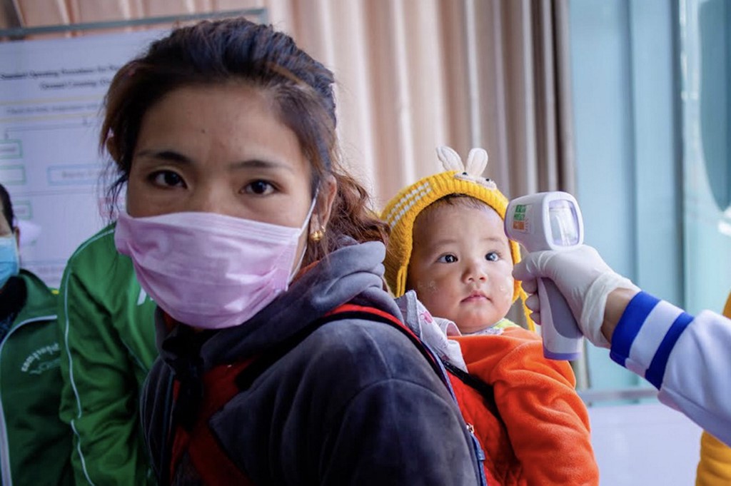  A Myanmar health officer checks the temperature of a child entering the Myanmar-China border crossing checkpoint in Muse, Shan State on January 31, 2020. (Phyo Maung Maung / AFP)