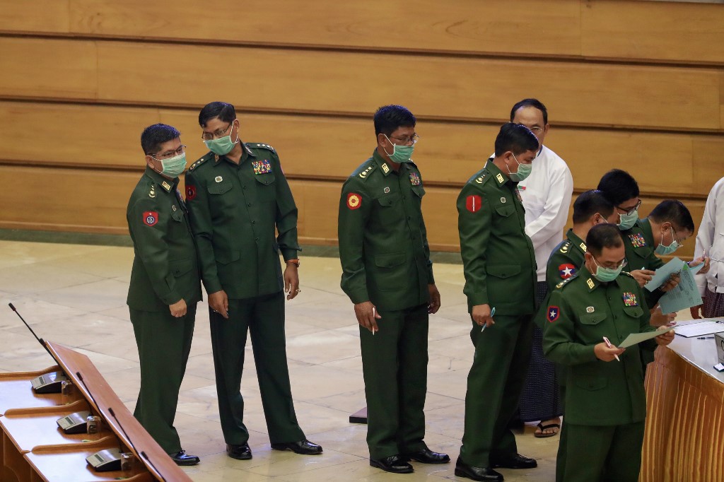 Military officers wearing facemasks who serve as members of Myanmar's parliament line up to vote during a session at the Assembly of the Union (Pyidaungsu Hluttaw) in Naypyidaw on March 10, 2020. (Ye Aung Thu / AFP)