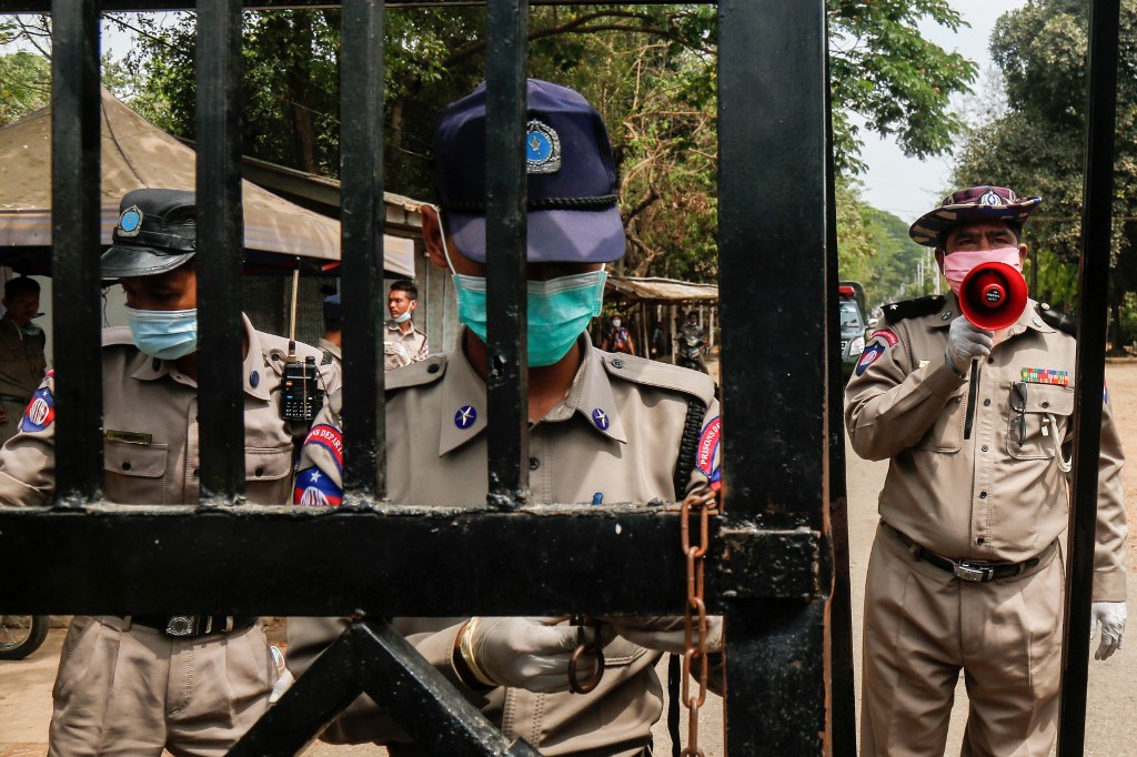 Prison officials, wearing face masks as a preventive measure against the spread of the COVID-19 novel coronavirus, stand guard in front of Insein Prison. (Sai Aung Main)