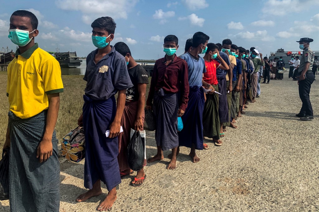 Released Rohingya prisoners wearing face masks amid concerns of the COVID-19 coronavirus pandemic arrive in Sittwe jetty in Rakhine State after being transported by military boat on April 20, 2020. Myanmar sent more than 800 Rohingya back to its restive Rakhine state April 20 after releasing them from various overcrowded jails as the country, accused of genocide against the minority, tries to grapple with the coronavirus crisis. (STR / AFP)