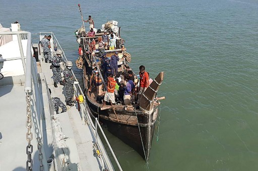 In this picture taken on May 2, 2020, Rohingya refugees stranded at sea are seen on a boat near the coast of Cox's Bazar. Dozens of Rohingya refugees believed to have come from two boats stranded at sea for weeks as they tried to reach Malaysia landed on the Bangladesh coast on May 2, Rohingya community leaders said. (STR / AFP)