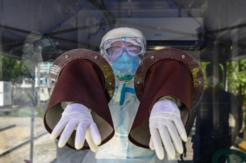 A medical officer prepares their protective gear before performing tests for the COVID-19 coronavirus at a quarantine centre in Yangon on May 16, 2020. (Ye Aung Thu / AFP)