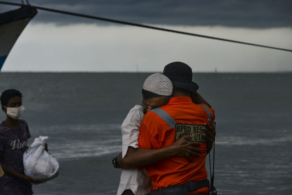 A Rohingya man from Myanmar hugs an Indonesian officer after being evacuated from a boat onto the shorelines of Lancok village, in Indonesia's North Aceh Regency on June 25, 2020. Nearly 100 Rohingya from Myanmar, including 30 children, have been rescued from a rickety wooden boat off the coast of Indonesia's Sumatra island, a maritime official said. (Chaideer Mahyuddin / AFP)