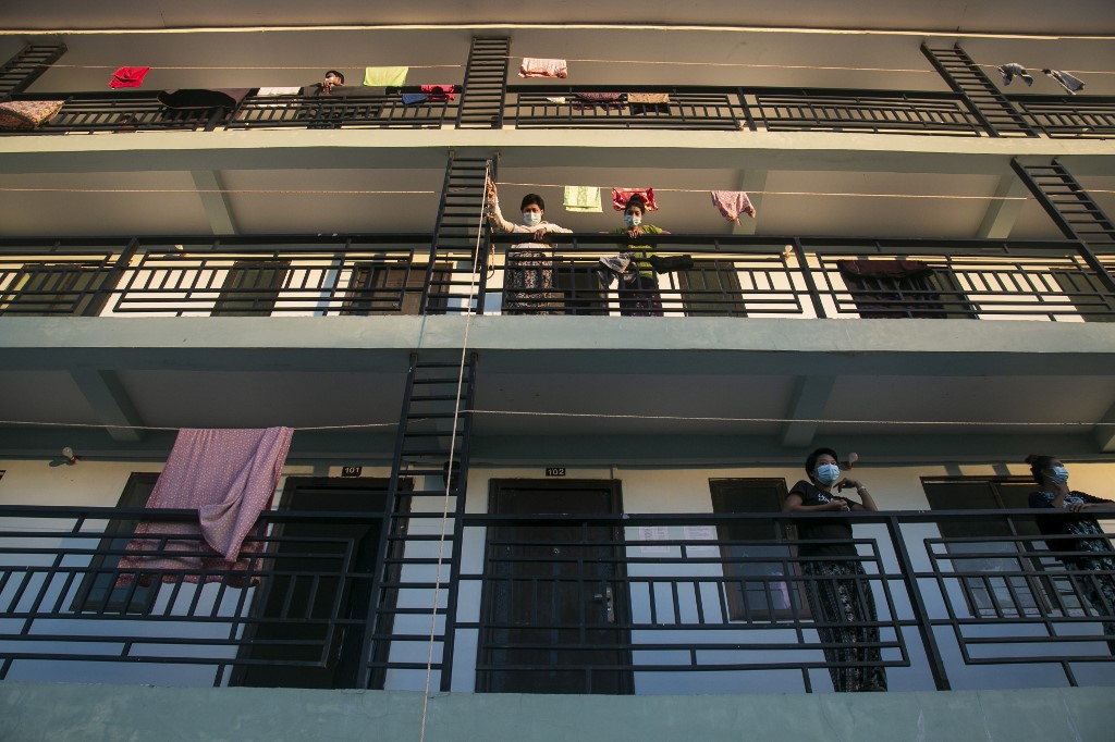 People in quarantine suspected of having the Covid-19 coronavirus wait for food delivered by volunteers at a medical facility in Myanmar on October 12, 2020. (Sai Aung Main / AFP)