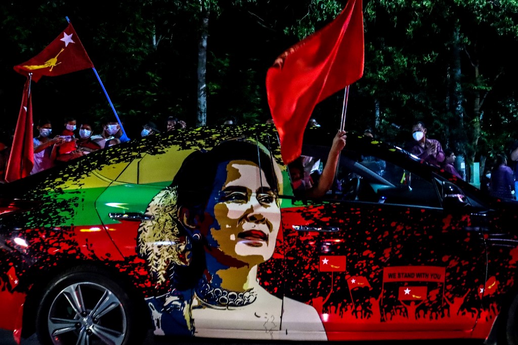 upporters of the National League for Democracy (NLD) party wave flags in front of the party's office in Mandalay on November 8, 2020, as ballots for the parliamentary elections are being counted after the polls closed. (Ye Naing Ye / AFP)