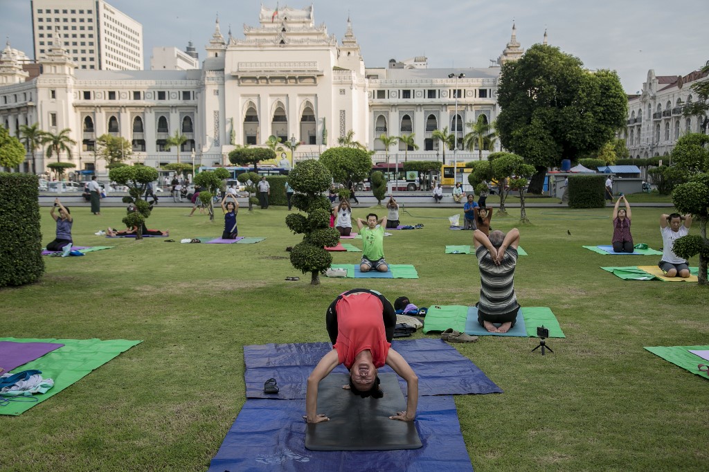 People practice yoga in Maha Bandula Park in downtown Yangon on December 4, 2020. (Sai Aung Main / AFP)