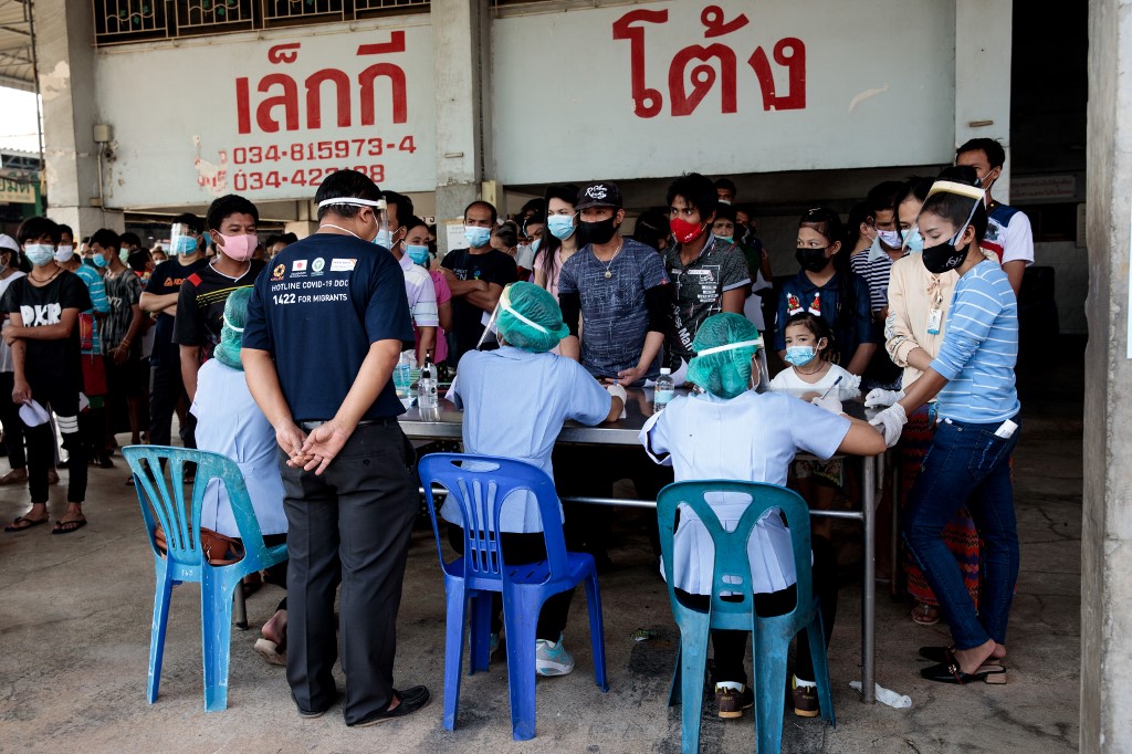 People queue to get tested for the Covid-19 at a seafood market in Samut Sakhon on December 19, 2020 after some cases of local infections were detected and linked to a vendor at the market. (Jack Taylor / AFP)
