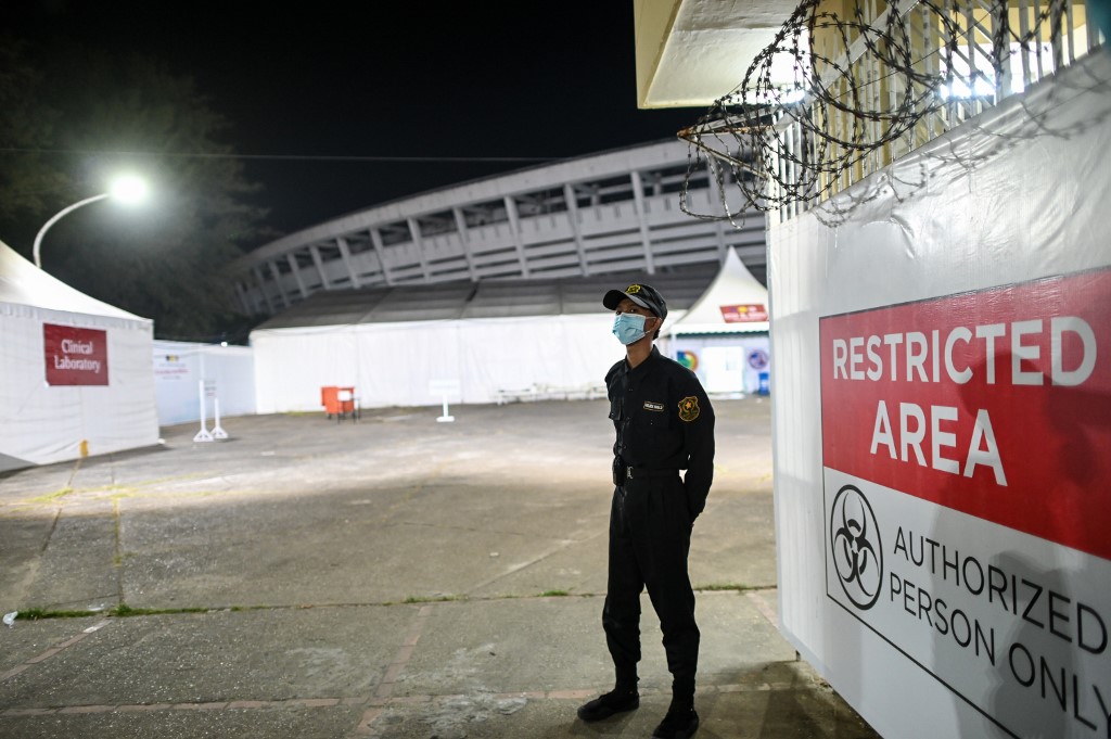 A security guard stands next to the intensive care unit (ICU) of the Ayeyarwady Covid Centre at the Thuwunna Stadium in Yangon, amid the ongoing Covid-19 coronavirus pandemic. (Photos by Ye Aung Thu / AFP)