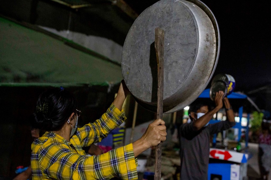 People clatter pans and tins to make noise to protest the military coup in response to a social media campaign in Yangon on February 2, 2021, as the party of Myanmar's toppled leader Aung San Suu Kyi demanded her immediate release Tuesday. (STR / AFP)