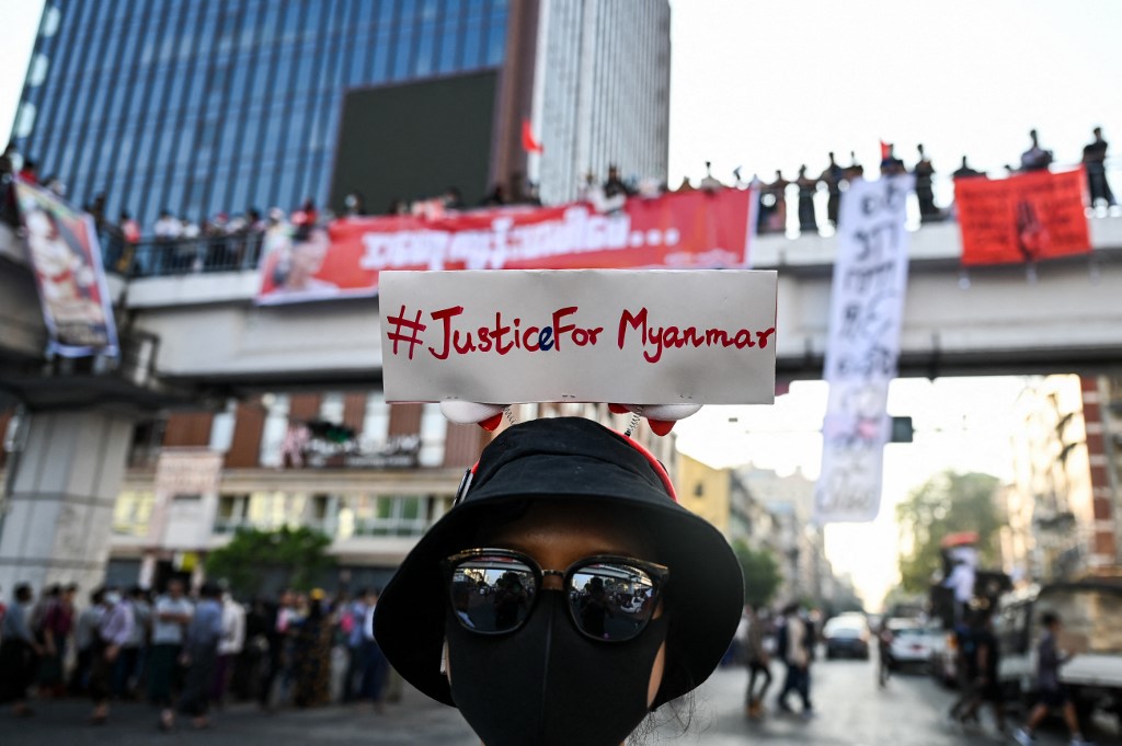A protester wears a sign with a hashtag #justiceformyanmar as they take part in a demonstration against the military coup in Yangon on February 8, 2021. (Ye Aung Thu / AFP)