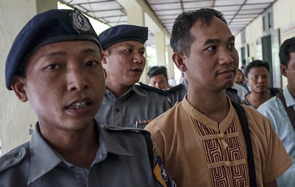 Swe Win (C), the editor of Myanmar Now, is escorted to a court by police in Mandalay on July 31, 2017. (AFP)