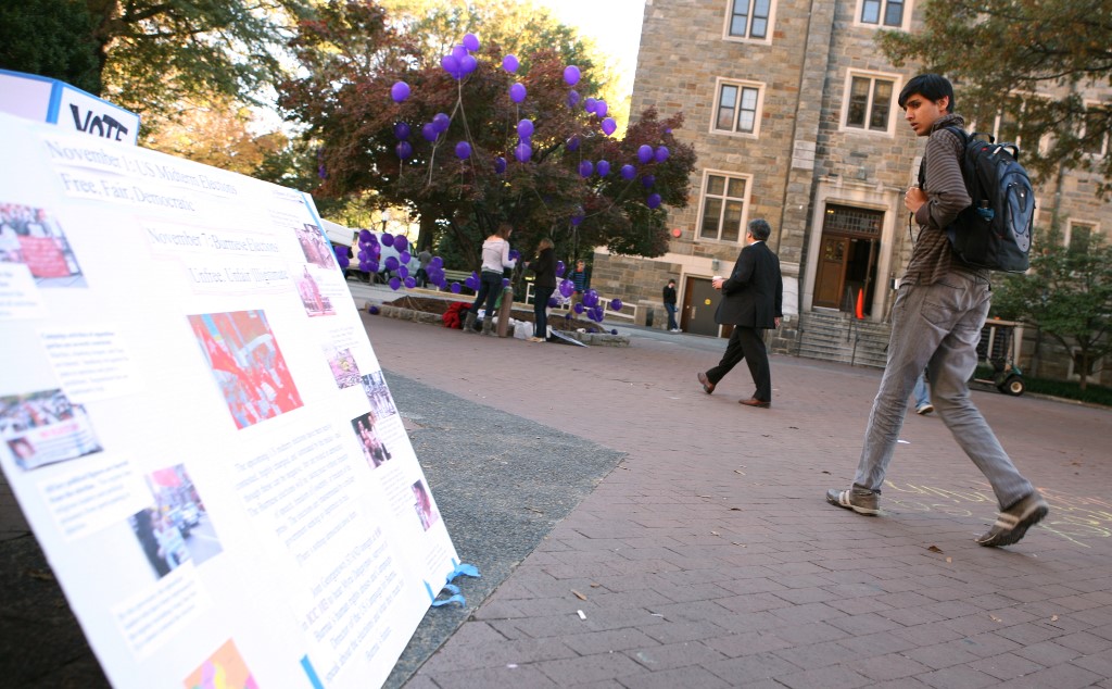  This photos from 2010 shows a Georgetown University student looks at the poster that encourages students to vote in a mock election of Burma as he walks by on campus. (AFP)