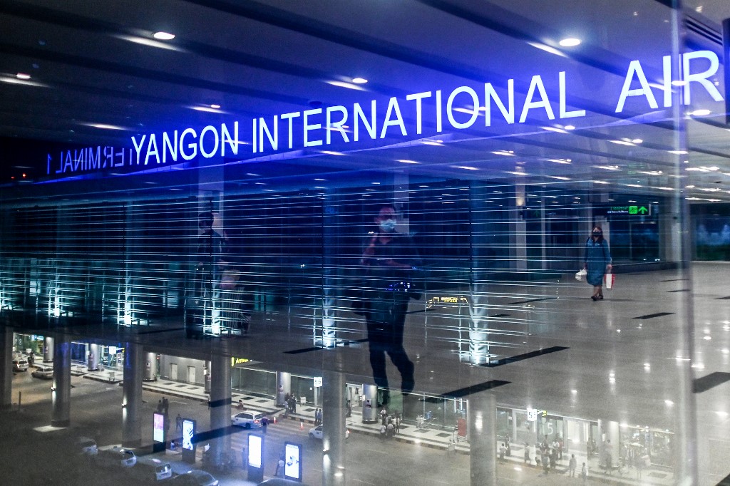 People wear facemasks amid concerns of the spread of the COVID-19 coronavirus while walking at Yangon International Airport in Yangon on March 18, 2020. (Ye Aung Thu / AFP)