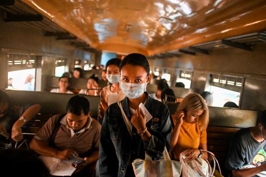 A passenger wears a facemask amid concerns of the spread of the COVID-19 coronavirus, as she walks inside a train at Yangon Railway Station in Yangon on March 18, 2020. (Ye Aung Thu / AFP)