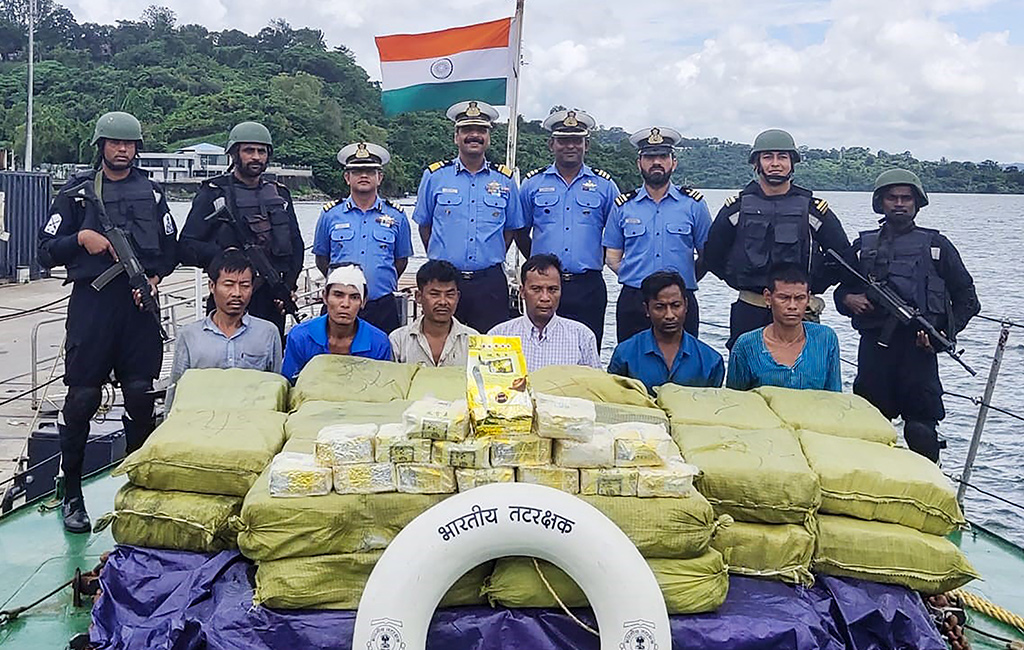 In this handout photograph taken by India's Ministry of Defence on September 19, 2019, Indian Coast Guard personnel (up) pose for photographs as they keep watch on a Myanmar ship's crew after seizing 1160 kg of Ketamine drug from their boat near Car Nicobar islands, part of the Indian union territory of Andaman and Nicobar islands. (AFP / handout)