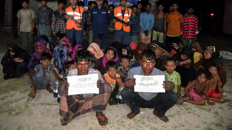 Bangladesh Coast Guard pose for a photo with rescued Rohingya refugees in Teknaf on May 31, 2019. (AFP)