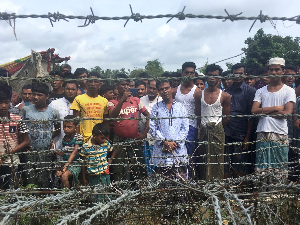 Rohingya refugees gather near the fence in the "no man's land" zone between Myanmar and Bangladesh border as seen from Maungdaw, Rakhine state during a government-organized visit for journalists on August 24, 2018. (Hla Hla Htay / AFP)