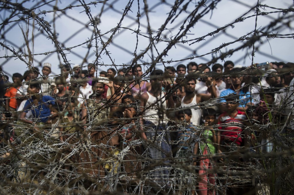 In this file photo taken on April 25, 2018, taken from Maungdaw district, Myanmar's Rakhine state on April 25, 2018 shows Rohingya refugees gathering behind a barbed-wire fence in a temporary settlement setup in a "no man's land" border zone between Myanmar and Bangladesh. (Ye Aung Thu / AFP)