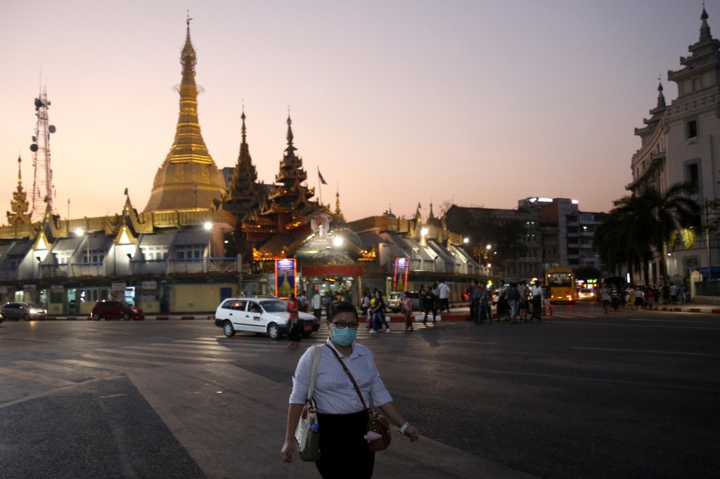 A woman wears a facemask amid concerns of the spread of the COVID-19 coronavirus while walking along a street, in Yangon on March 17, 2020. (Sai Aung Main / AFP)