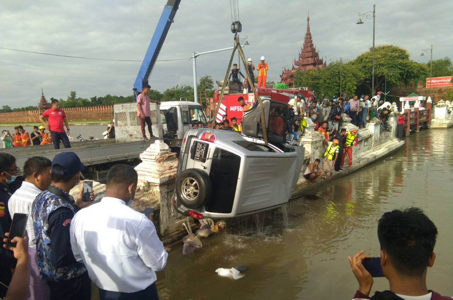 A crane truck lifts the vehicle that crashed into the moat of Mandalay Palace on 25 August. (Zaw Lin Oo)