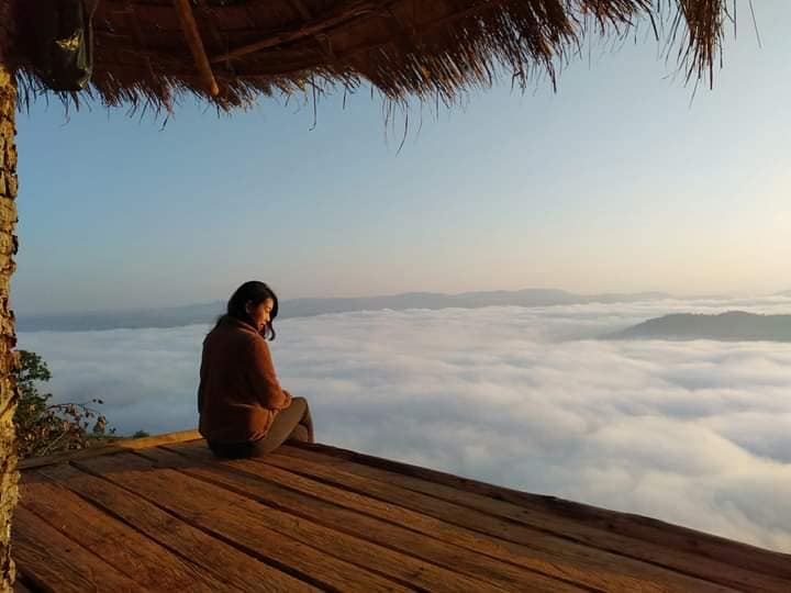A visitor sits above a blanket of clouds at Cloudy Villa in northern Shan State. (Cloudy Villa / Facebook)