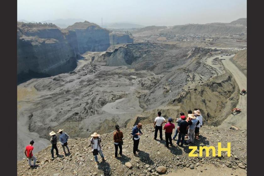   Observers look at the worksite that was flooded with mud after the dam breach on the outskirts of Kachin state's Hpakant township. (Zaw Moe Htet)