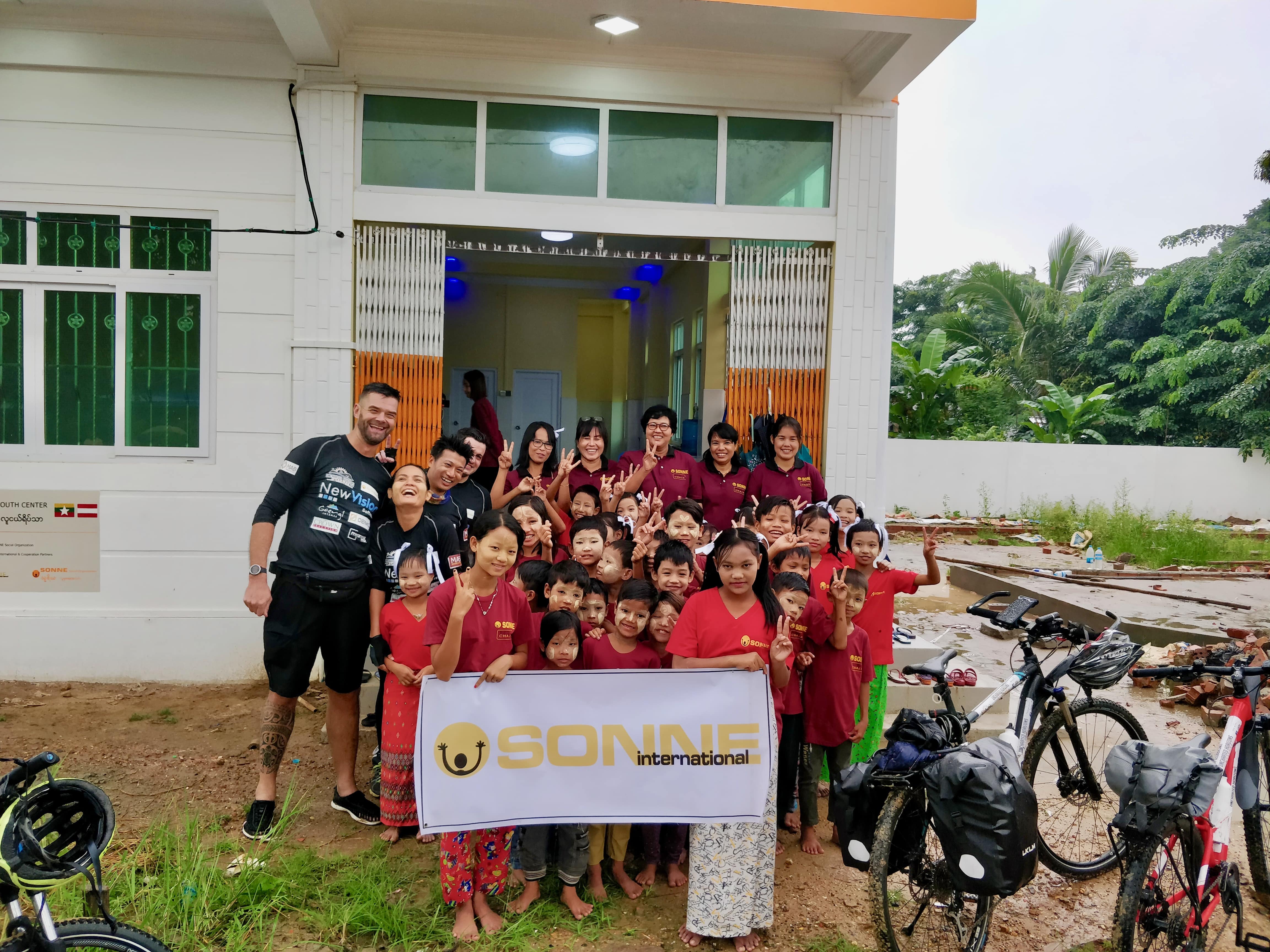 The adventurers begin their cycle to Singapore from the new SONNE International children's centre in Yangon. (Myanmar Mix)