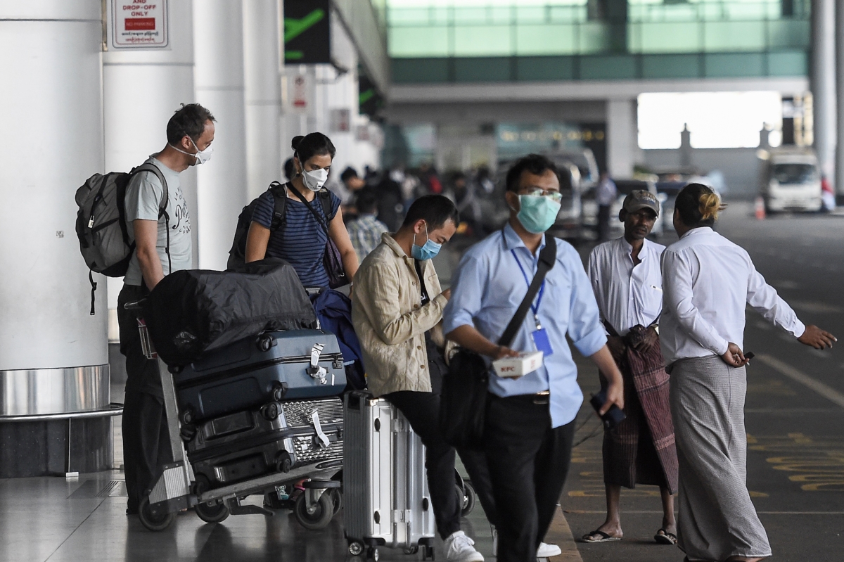 Travellers wear face masks outside Yangon International Airport. (AFP)