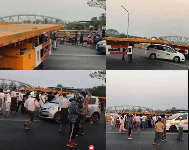 People push a truck trailer blocking the way to Yangon. (Supplied)