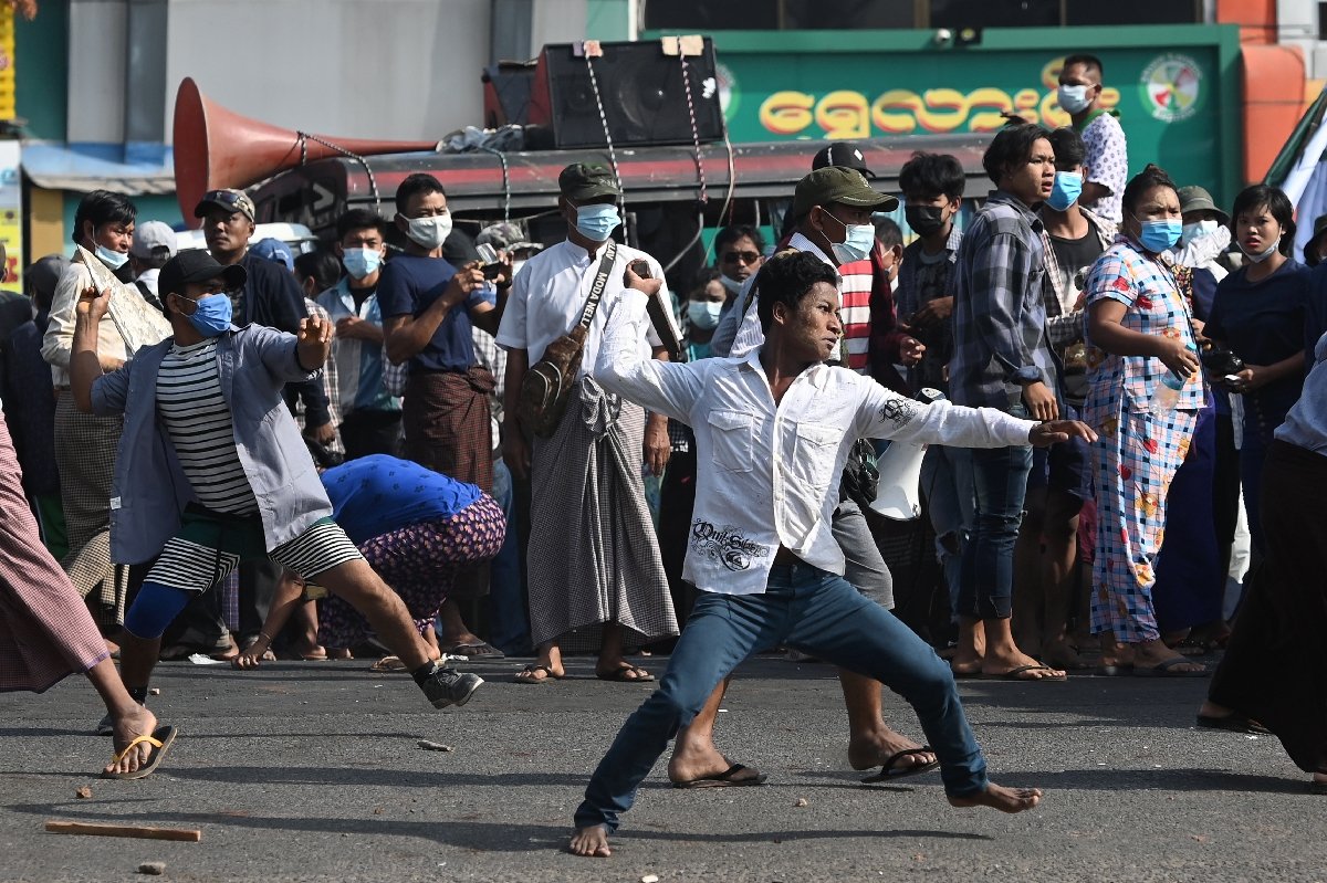 Supporters of Myanmar's military throw objects at residents in Yangon on Thursday (Sai Aung Main / AFP)