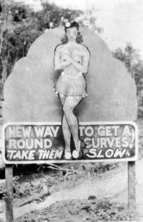 An illustration of a pin-up model, advising drivers to take curves slow.