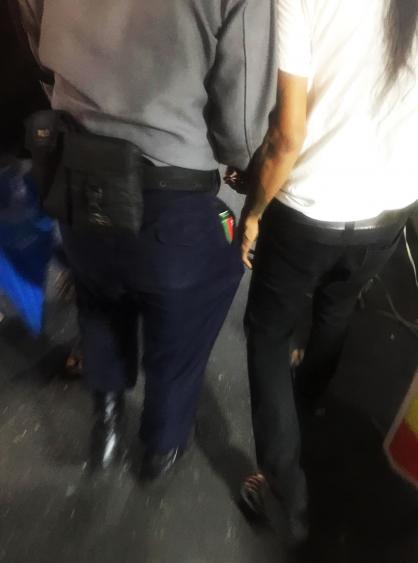 This photograph reportedly taken during the arrest shows a police officer with a Myanmar Beer in his pocket.
