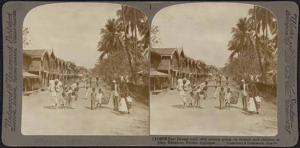East Bazaar Road, with porters going on errands and children at play, Rangoon.