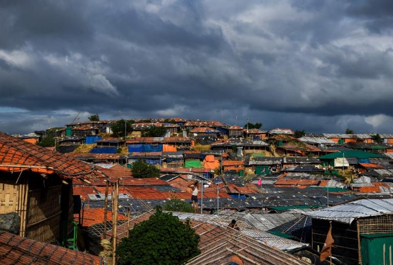 A Rohingya refugee man stands atop of a tent in Kutupalong camp in Ukhia near Cox's Bazar on August 12. (Chandan Khanna / AFP)