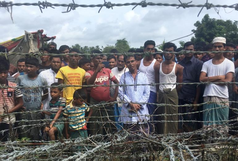 Rohingya refugees gather near the fence in the "no man's land" zone between Myanmar and Bangladesh border as seen from Maungdaw, Rakhine state during a government-organized visit for journalists on August 24, 2018. (Hla Hla Htay / AFP)