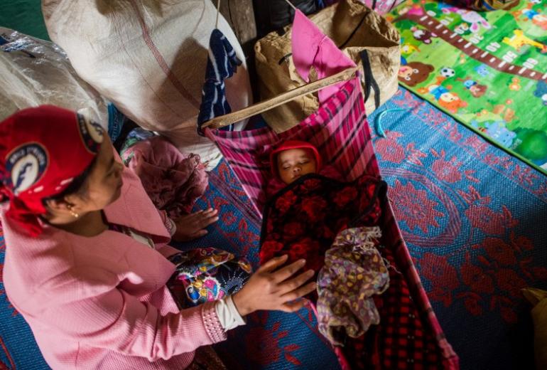 A woman sits next to her child in a monastery-turned-temporary shelter for internally displaced people (IDP) in Hsipaw, Shan State. (Ye Aung Thu / AFP)