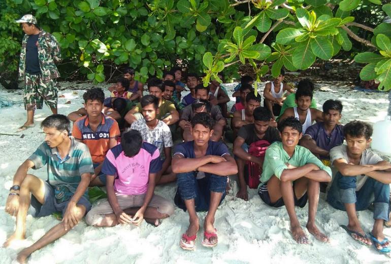  A group of Rohingya Muslims sit on the sand at the Tarutao Marine National Park on Rawi island, southern Thailand. (Handout / Department of National Parks, Wildlife and Plant Conservation / AFP)