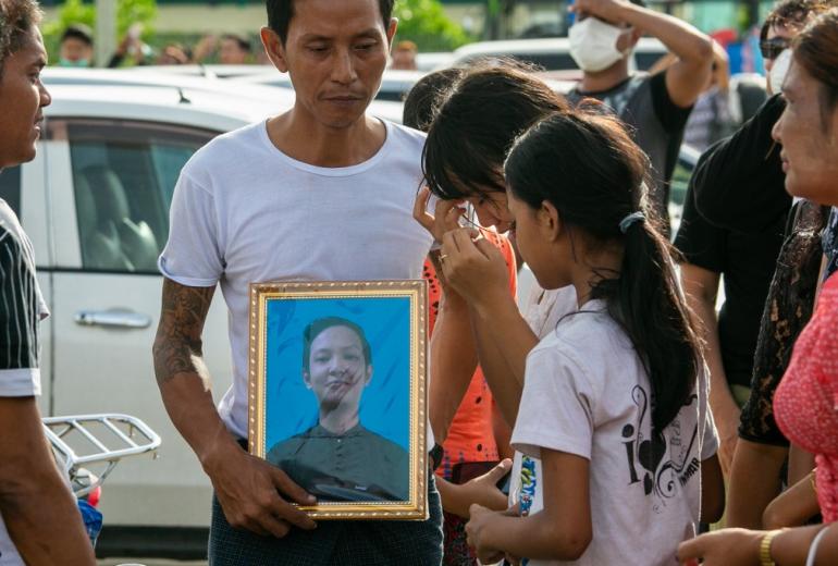 A relative holds a photograph of Kyaw Zin Win, a gay Myanmar man who took his own life after facing alleged homophobic bullying, during his funeral in Yangon on June 26, 2019. (Sai Aung Main / AFP)