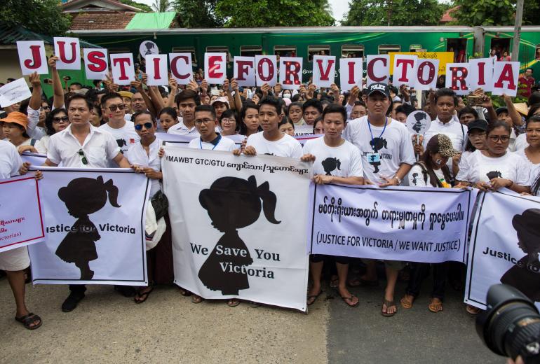 Protesters hold signs during the demonstration demanding justice for a two-year-old who was raped and given the pseudonym "Victoria" in front of the Central Investigation Department (CID) in Yangon on July 6, 2019. (Sai Aung Main / AFP)
