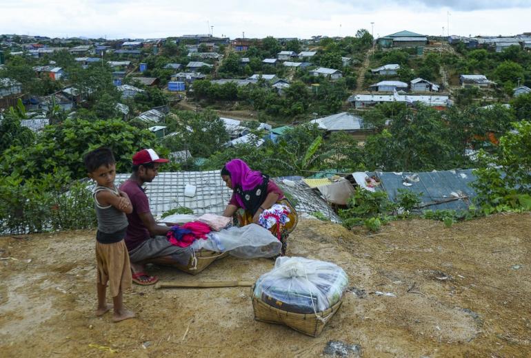 A Rohingya woman buy cloths from a vendor at Kutupalong refugee camp in Ukhia on July 24, 2019. (Munir Uz Zaman / AFP) 