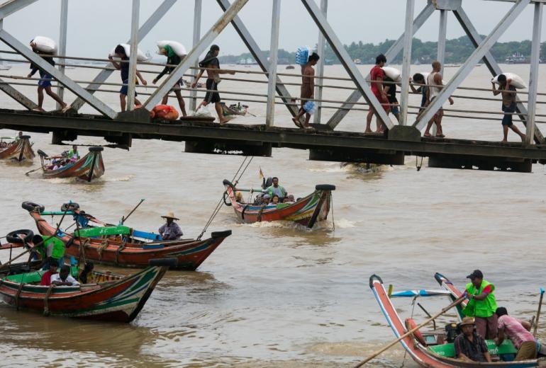 This photograph taken August 1, 2019 shows people from Dala township arriving by boat in Yangon after crossing the Yangon River. (AFP)